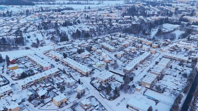 Snow-covered houses and streets in the suburbs. The harsh and cold winter makes life difficult. View from a drone. Svitavy, Czechia