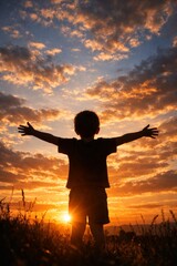 Fototapeta premium Silhouette of joyful boy with arms wide open against stunning sunset sky. Vertical composition adds drama. Happy childhood moment evokes freedom and wonder. Perfect for family lifestyle themes.