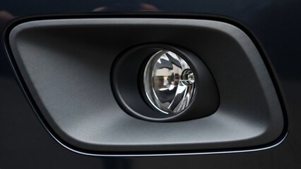 Close-up of a car's fog light with sleek design and modern aesthetic.