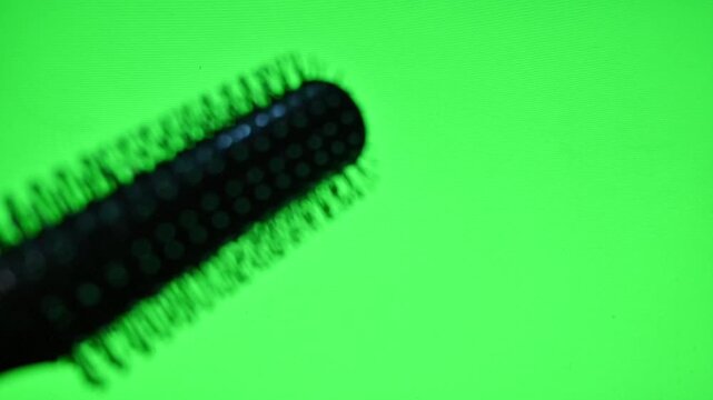 Footage of a black comb on green screen background. ideal for beauty ads, mock-up's, packaging design, and hair care content with replaceable background