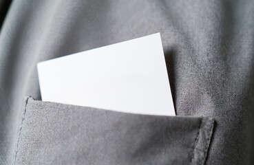 Blank white card tucked into gray fabric pocket. Item is ready for text or design. Copy space available for custom message. Neutral background texture.