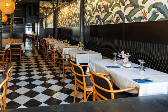 Stylish restaurant interior with checkered floor and wallpaper