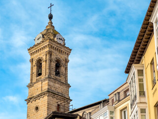 Fototapeta premium Historic clock tower in the old center of Vitoria Gasteiz, Basque Country, Spain. Bright blue sky and classic architecture, perfect for travel and city themes. High quality photo
