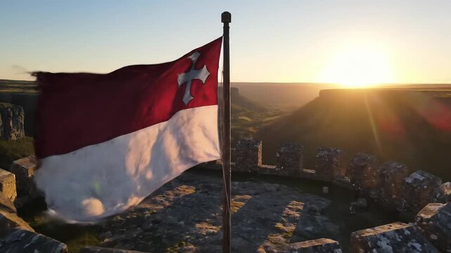 Ancient castle ruins with a flag flying at sunset, epic historical landscape
