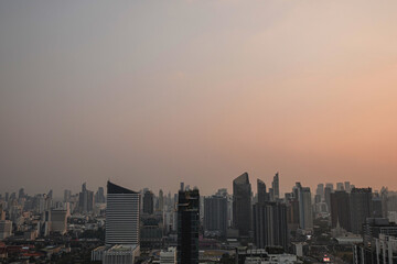 Fototapeta premium Modern city skyline at dusk with high rise buildings under hazy evening sky