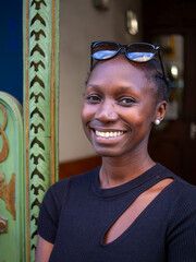 A beautiful woman smiling while looking at camera next to a Art noveau door, Modernism architecture