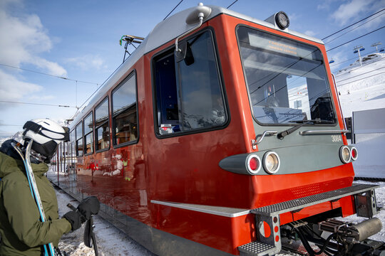 Gornergrat train arriving at the station to pick up skiers in Zermatt, Switzerland in a sunny winter day