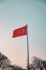 Turkish national flag waving against pastel sky at sunset