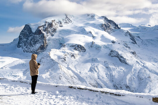 Person Observing the glaciar and Expansive Snowy Mountains in Zermatt Alps. Gornergrat 