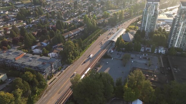 Cityscape Of Burnaby, Canada On Sunny Morning With Bustling Roads, Rapid Transit Line, And Highrise Buildings. aerial shot