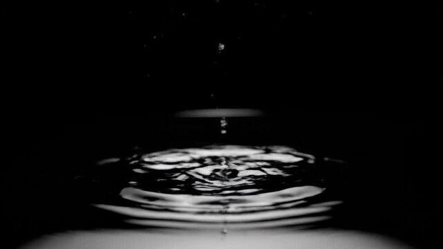 A dark scene showing water in motion, creating a complex splash effect