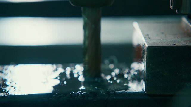 watercooled milling through metal block with cascading coolant and metal chips, closeup of rotating end mill carving precise slot, cool blue workshop tones, industrial machining