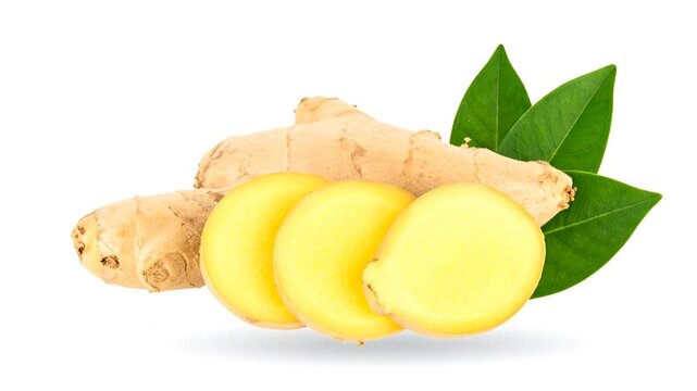 Close-up of sliced yellow ginger root, brown ginger, and green leaves on white background