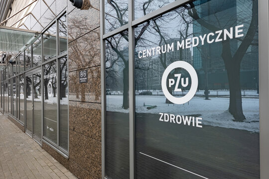 WARSAW, POLAND - JANUARY 7, 2026: Exterior facade of the PZU Zdrowie medical center featuring the company logo and signage on the glass window during a snowy winter day