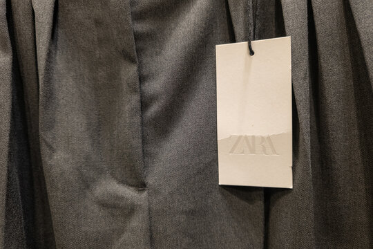 WARSAW, POLAND - JANUARY 21, 2026: A close-up view of a Zara brand label attached to a dark grey garment in a clothing store