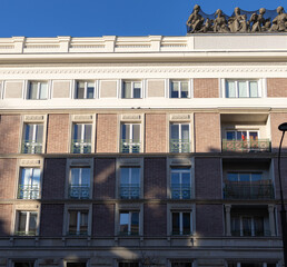Obraz premium Building with sculptures on the roof, against clear sky and afternoon light