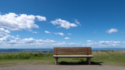 Scenic Wooden Bench Overlooking Endless Sky and Quiet Landscape under Blue Clouds