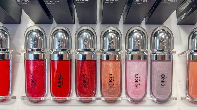Malaga, Spain - December 21, 2025: Kiko Milano lipsticks displayed on a store stand with various shades including red, pink, and nude in sleek packaging and visible branding