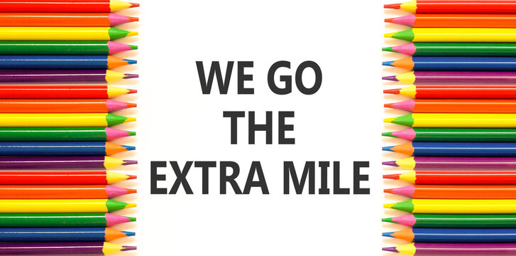 Support, help we go the extra mile symbol. Concept words We go the extra mile on beautiful white paper. Beautiful white background. Colored pencils. Business we go the extra mile concept. Copy space.
