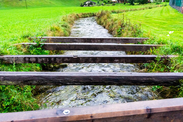 Fototapeta premium Wooden beams over a stream near Lofer, Austria.