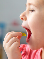Child eating jelly candies at home. Selective focus.