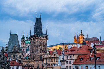 Fototapeta premium A panoramic view of Prague’s historic skyline featuring Gothic towers, red rooftops, and ornate architectural details. The scene captures timeless European charm, old town ambiance
