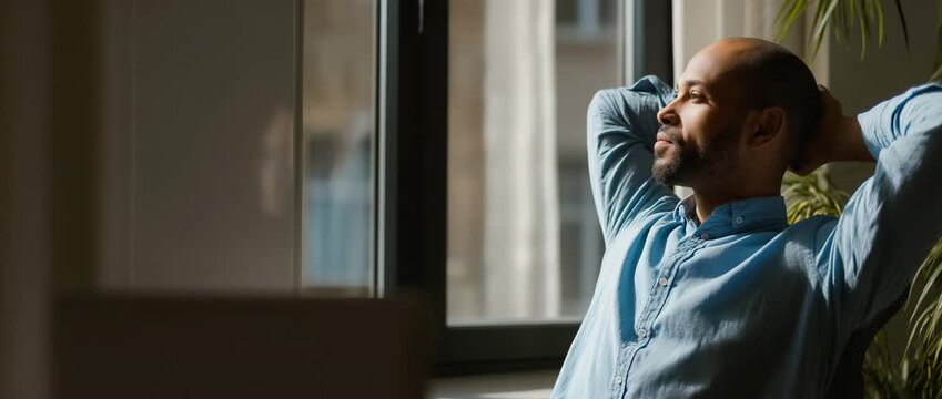 Person taking short pause from work, looking out window, calm reset moment, work-life balance

