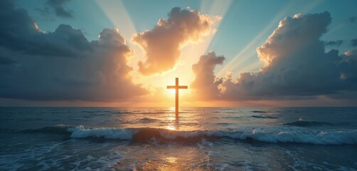 Wooden cross stands in calm ocean water under dramatic cloudy sky with sun rays. Gentle waves wash shore at sunrise sunset. Hopeful religious scene.