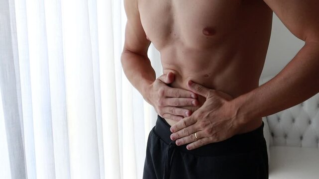 homem com dor no estomago, m&atilde;os sobre a barriga 