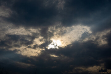 Obraz premium Dramatic dark clouds with sun hiding behind