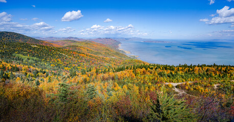 Majestic view over the coast of St-Lawrence river and wonderful colored foliage of Autumn from Massif mountain, Charlevoix, Quebec, Canada