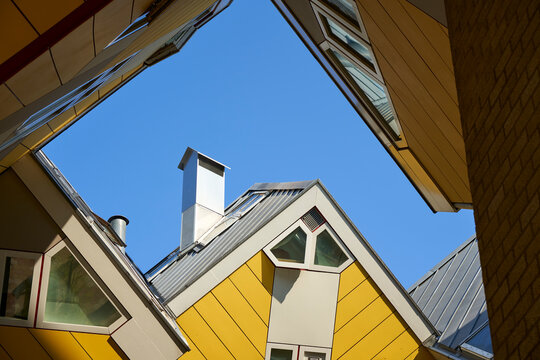 The famous Cube Houses in Rotterdam feature unique architecture with slanted angles and yellow roofs. These modern buildings are a popular tourist attraction in the Netherlands.