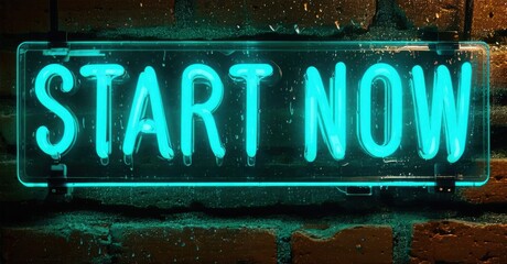 Bright neon sign displays Start Now against textured brick wall. Vivid turquoise glow dominates dark background. Inspiring message.