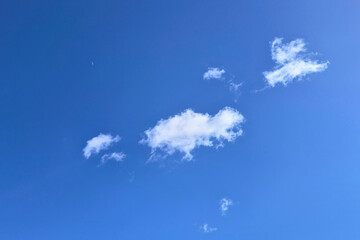 Beautiful blue blue sky with soft white clouds. Floating clouds in blue sunny sky. Minimal clear summer sky background. Sky background for spring project