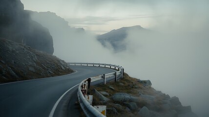 Fototapeta premium A winding coastal road disappears into thick fog and mountainous terrain