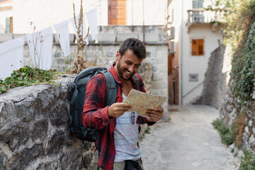 Young man with backpack and map exploring a historic old town