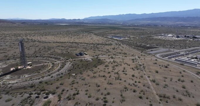 Solar Almeria research centre Spain aerial over solar tower and circular heliostat mirror field showing renewable energy technology in arid landscape