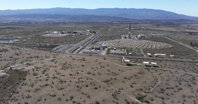 Wide aerial establishing of Solar Almeria research centre with solar tower and heliostat mirror field in arid Andalusia Spain
