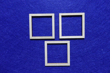 Three wooden square frames arranged on a blue background