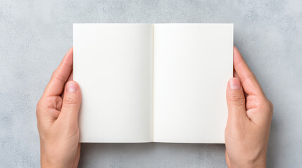 Blank open notebook held by hands on textured surface, minimal style close up of hands holding small notebook, clean white pages ready for writing or drawing