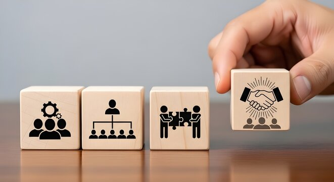 Wooden blocks displaying icons of teamwork, organizational structure, problem solving, and partnership, with a hand placing a collaboration block, corporate teamwork, effective business cooperation