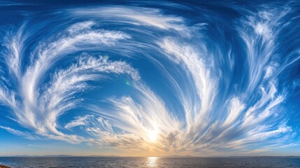 Striking cirrus clouds fan out across a deep blue sky above a calm ocean horizon at sunset