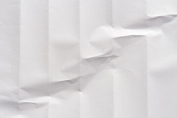 Crumpled white paper texture with creases and shadows for backgrounds or designs.