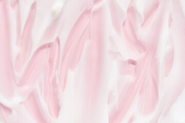 Obraz premium Smooth pink and white cream or lotion texture with soft swirls and brushstrokes for skincare or cosmetic product background.