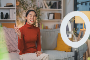 talented Asian musician and singer woman host an interactive acoustic live stream concert from home at night, utilizing professional ring lighting for a high-quality online influencer broadcast.