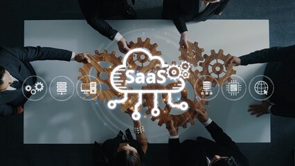 A diverse team collaborates over a table, showcasing gears representing SaaS technology and innovation, emphasizing teamwork and business growth through effective digital solutions. Raster