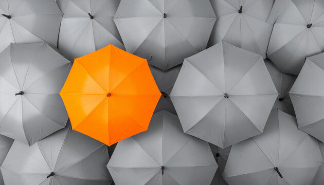 Ein besonderer orangener Regenschirm zwischen vielen grauen Regenschirmen