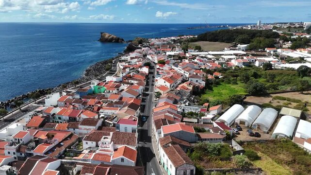 Sweeping aerial photograph of Ponta Delgada coastline on S&atilde;o Miguel Island with volcanic landscape and urban expansion.