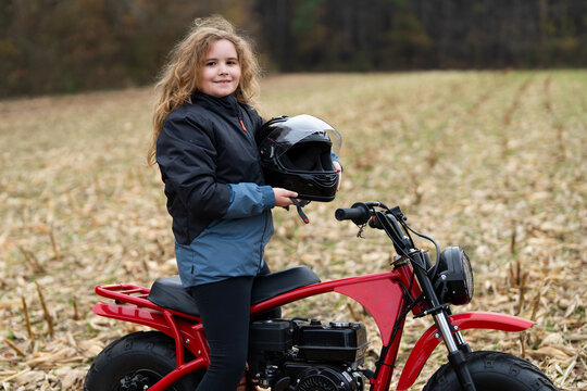 Child motorbike youth adventure. Kid motor bike holding helmet. Kid motorbike active child. Kid motorbike countryside racing. Kid motorbike outdoor speed.