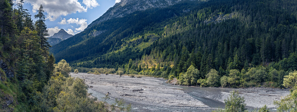 Pristine nature in the Tiroler Lech Nature Park and Natura 2000 protected area, Tyrol, Austria. Forested mountain slopes and wild river landscapes offering untouched tranquility and scenic wilderness.